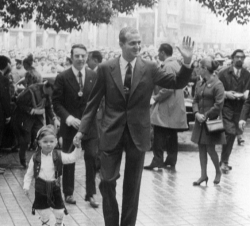 El Príncipe Juan Carlos, acompañado del Infante Felipe ataviado con un traje de maño, saluda al público que asiste a la tradicional ofrenda floral a l